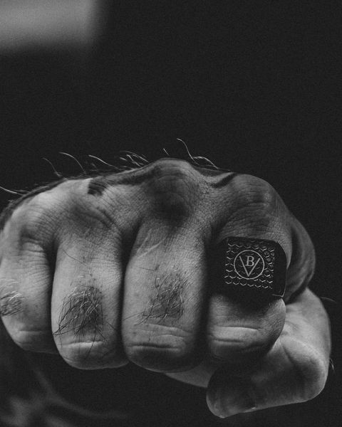 A closed fist wearing a signet ring engraved with the BV touchmark
